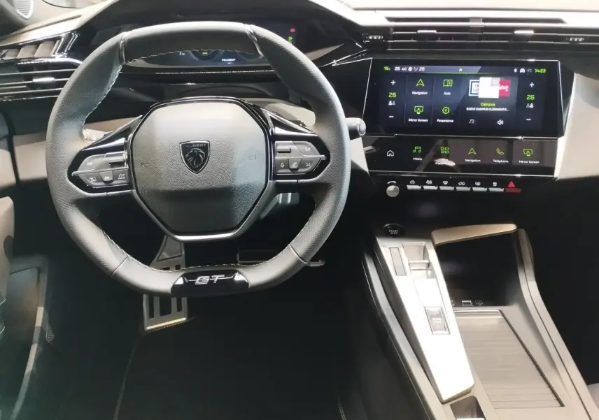 Vue intérieure centrée sur le volant GT cuir noir et l’écran tactile du tableau de bord de la Peugeot 308 gris selenium.