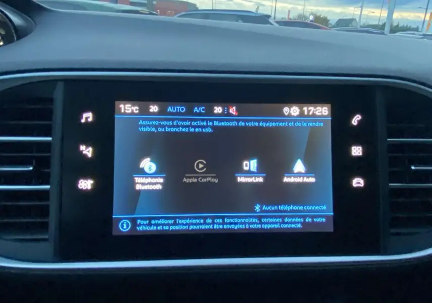 Écran tactile central de la Peugeot 308 gris clair, affichant les options Apple CarPlay et Bluetooth.