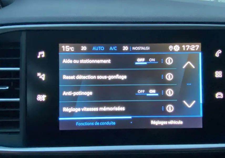 Écran tactile central de la Peugeot 308 gris clair, affichant les réglages d'aide au stationnement et conduite.