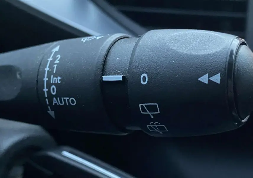Gros plan sur la commande d'essuie-glace de la Peugeot 308 gris clair, montrant les réglages automatiques et intermittents.