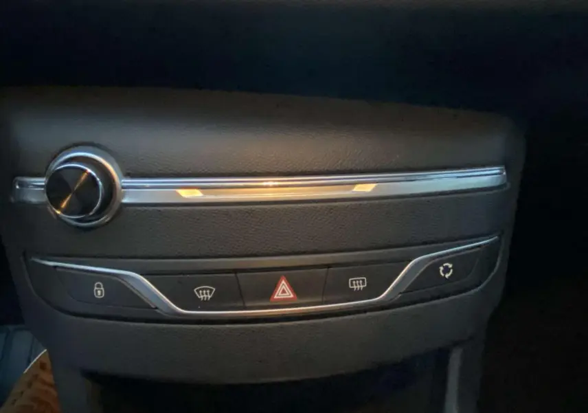 Gros plan sur la console centrale noire de la Peugeot 308 2020 avec boutons de verrouillage, warning et dégivrage.
