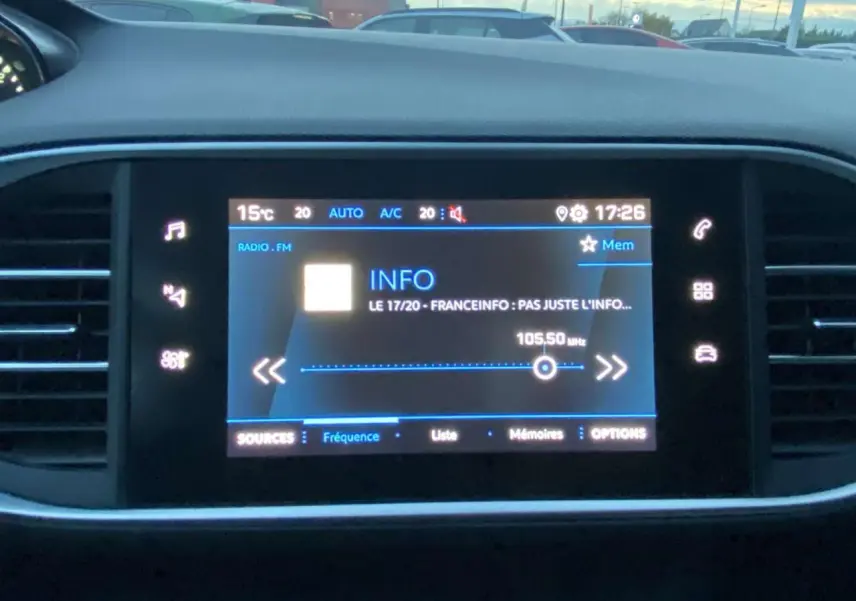 Écran tactile central de la Peugeot 308 gris clair, affichant la radio FM et commandes climatisation à 17h26.