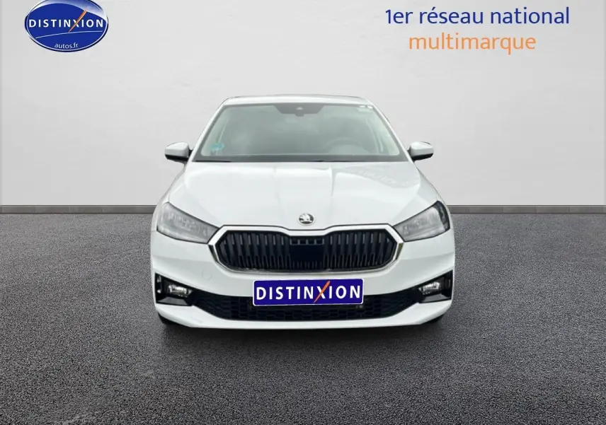 Vue frontale d'une Skoda Fabia blanche 2025 avec calandre noire et phares LED, sur fond neutre gris.
