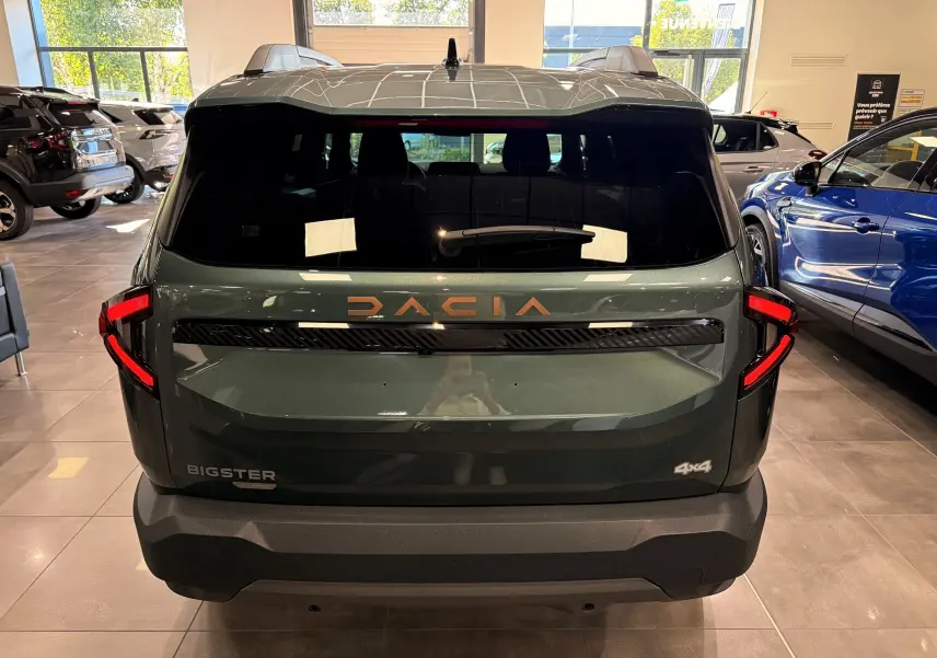 Vue arrière du Dacia Bigster Hybrid-G 150 4x4 en Vert Cèdre, avec logo DACIA lumineux et feux arrière en forme de C.