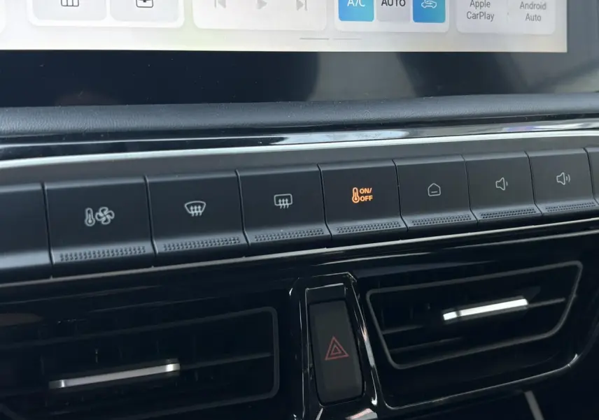 Gros plan sur la console centrale du MG3 2025, montrant les boutons de climatisation et les aérateurs noirs.