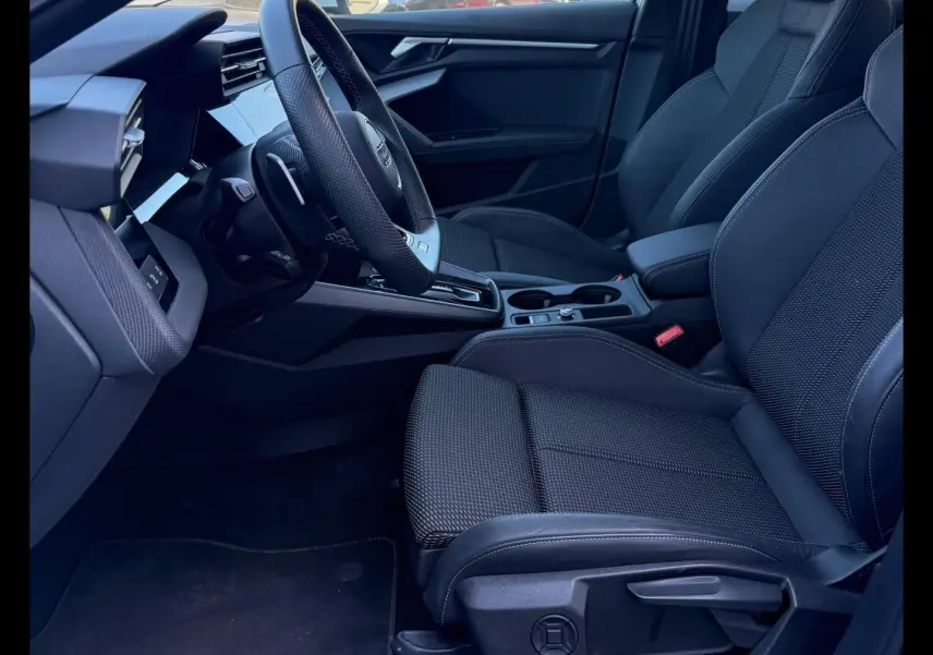 Intérieur avant droit de l’Audi A3 Sportback 40 TFSI e 2025 avec sièges sport noirs et volant cuir multifonction.
