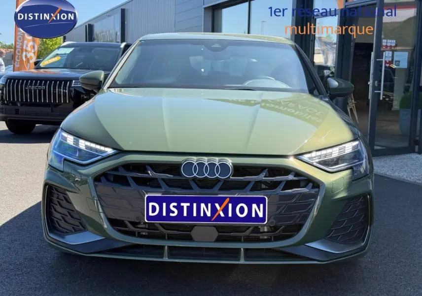 Vue de face d'une Audi A3 Sportback 40 TFSI e 204ch hybride en vert District métallisé avec calandre noire distinctive.