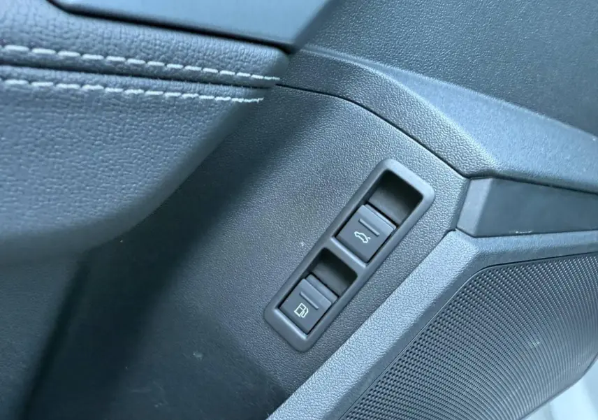 Détail des commandes d’ouverture du coffre et de la trappe à carburant sur la porte côté conducteur d’un Audi A3 Sportback vert District.
