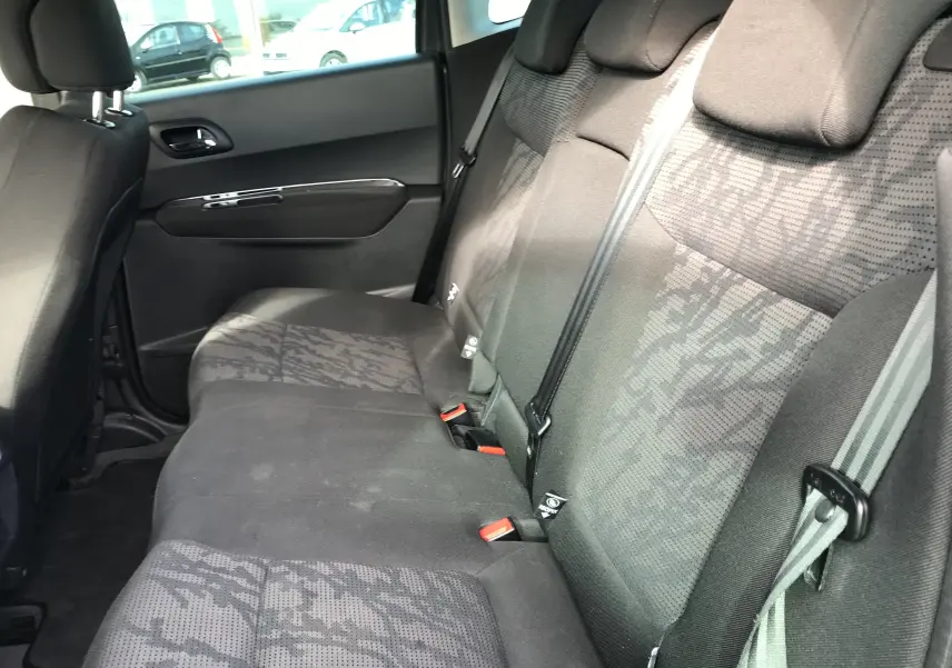 Vue intérieure côté droit des sièges arrière gris anthracite du Peugeot 3008 2011 avec ceinture de sécurité et appuie-têtes.