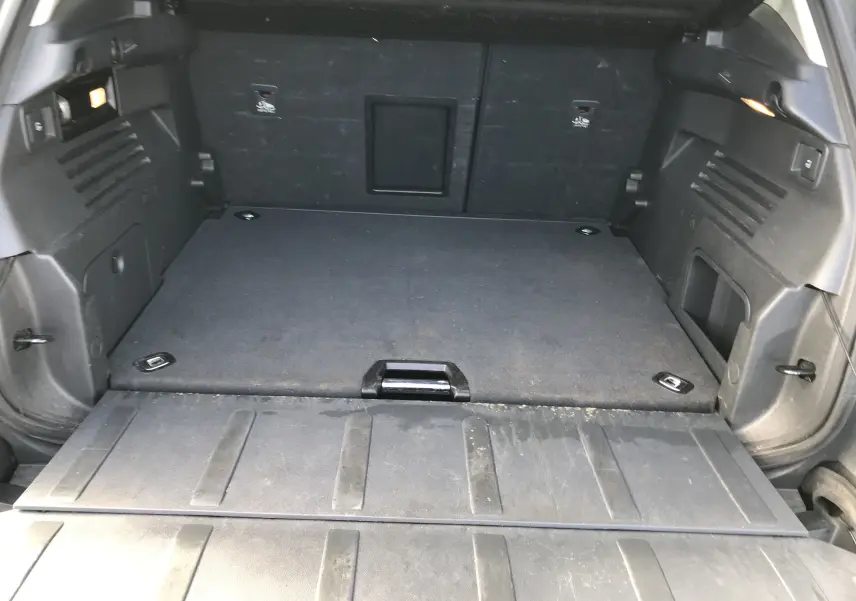 Coffre ouvert d'un Peugeot 3008 gris anthracite, vue de l'arrière montrant un espace de chargement plat et spacieux.