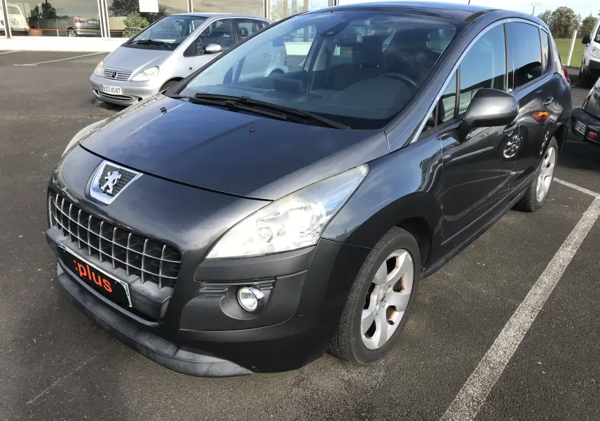 Peugeot 3008 gris anthracite vue 3/4 avant droit sur parking, avec calandre et phares distinctifs visibles.
