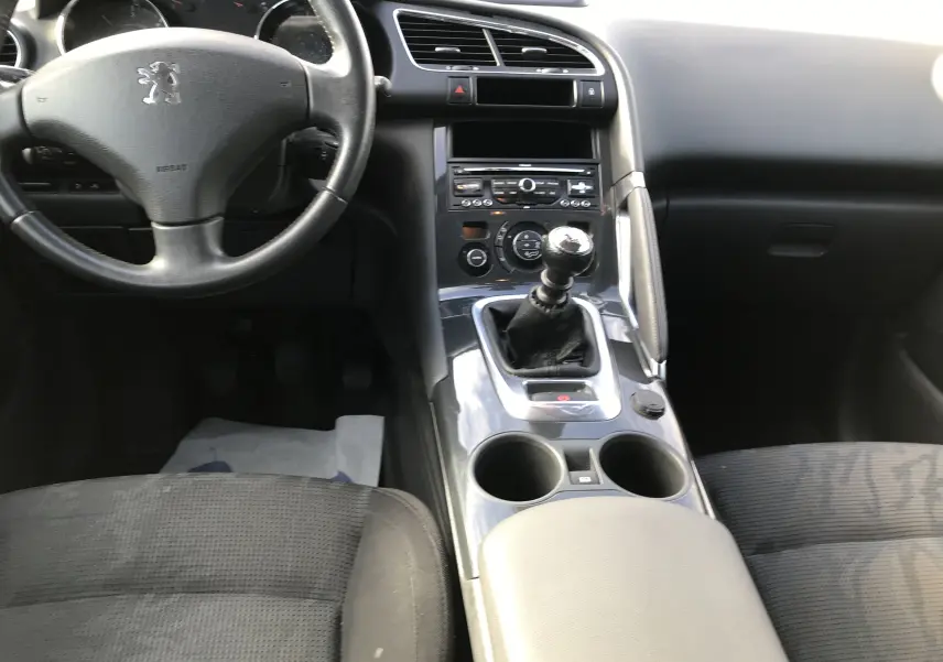Vue intérieure centrée sur le tableau de bord et la console centrale du Peugeot 3008 gris anthracite avec boîte manuelle.