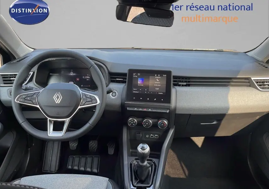 Intérieur de la Renault Clio 2025, vue frontale du tableau de bord avec volant multifonction et écran tactile central.