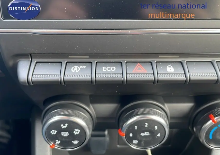 Gros plan sur les commandes de climatisation et boutons de fonction d'une Renault Clio 1.5 DCI 100CH Evolution noir étoile métal.