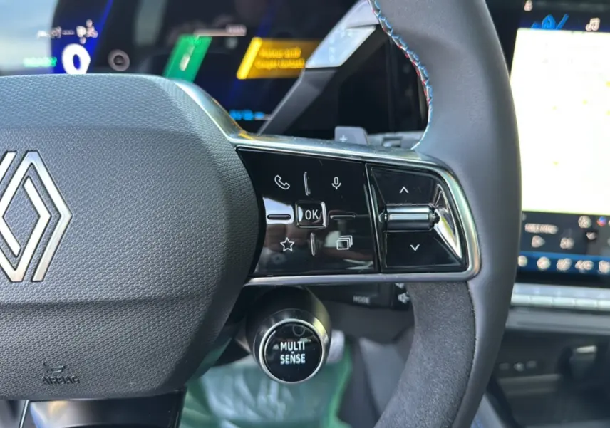 Gros plan sur le volant du Renault Austral New 200 Esprit Alpine 2025, avec commandes multifonctions et bouton Multi Sense.