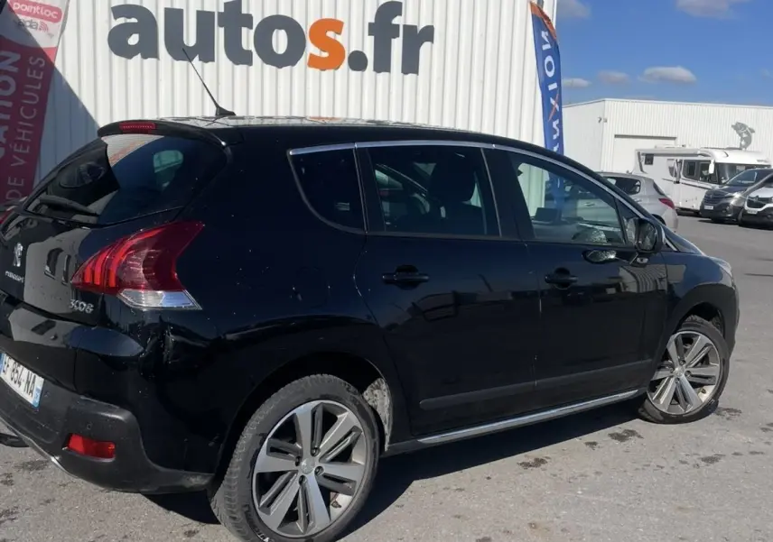 Peugeot 3008 noir vue de trois quarts arrière côté droit, stationnée devant un garage autos.fr par temps ensoleillé.