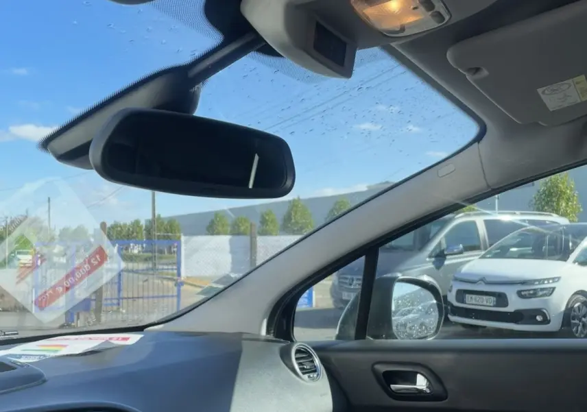 Vue intérieure côté passager avant du Peugeot 3008 noir, avec tableau de bord et rétroviseur central visibles.