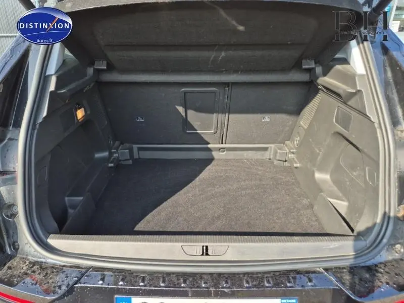 Coffre ouvert de l'Opel Grandland noir diamant métallisé, montrant un espace de chargement propre et bien agencé.