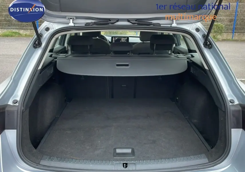 Coffre ouvert vu de l'arrière d'une SEAT LEON ST gris urbain métal, montrant un espace de chargement spacieux et propre.