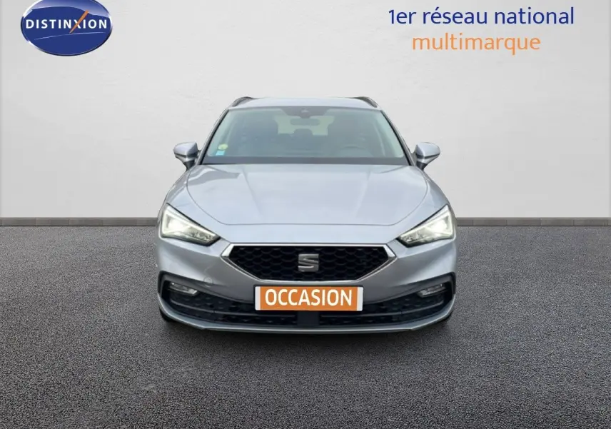 Vue frontale d'une SEAT LEON ST gris urbain métal avec calandre noire et plaque "OCCASION" orange.