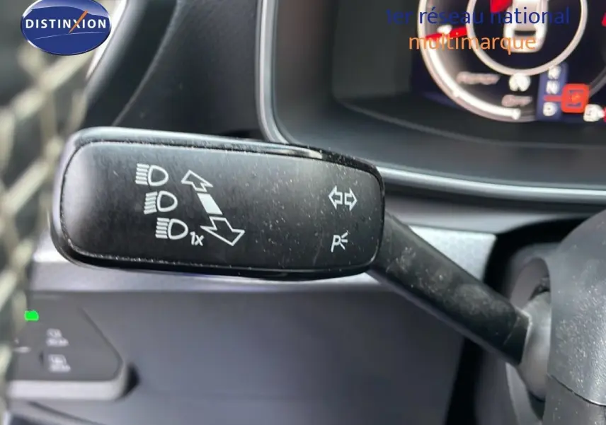 Gros plan sur la commande de clignotants et feux du tableau de bord d'une SEAT LEON ST gris urbain.