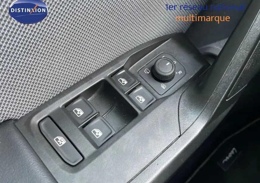 Gros plan sur les commandes de lève-vitres et rétroviseurs côté conducteur d'une SEAT LEON ST gris urbain 2022.
