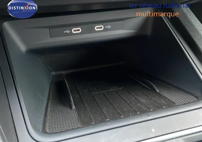 Gros plan sur le compartiment de rangement central avec ports USB-C dans une SEAT LEON ST gris urbain metal, vue intérieure.