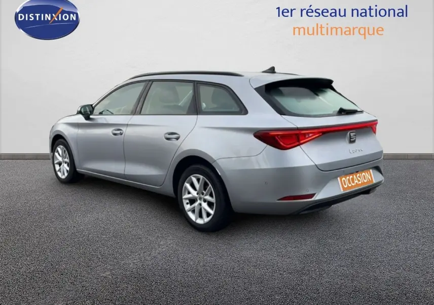 Vue 3/4 arrière droite d'une SEAT Leon ST gris urbain métal avec feux arrière allongés et toit panoramique.