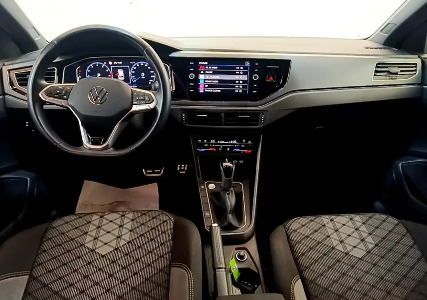 Vue intérieure avant du Volkswagen Taigo 1.5 TSI 150 DSG R-Line 2023, tableau de bord numérique et volant cuir noir.