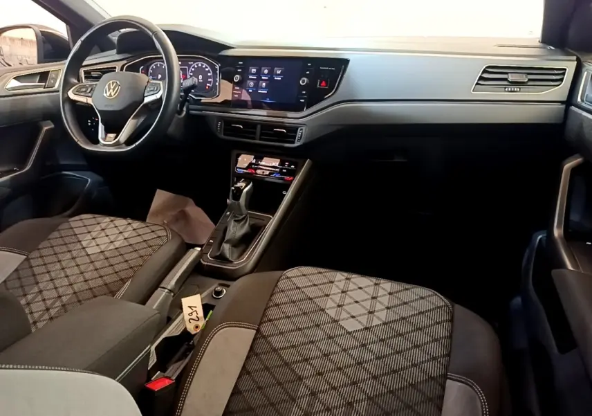 Vue intérieure avant droite du Volkswagen Taigo 1.5 TSI 150 DSG R-Line 2023, sièges tissu à motifs et tableau de bord digital.