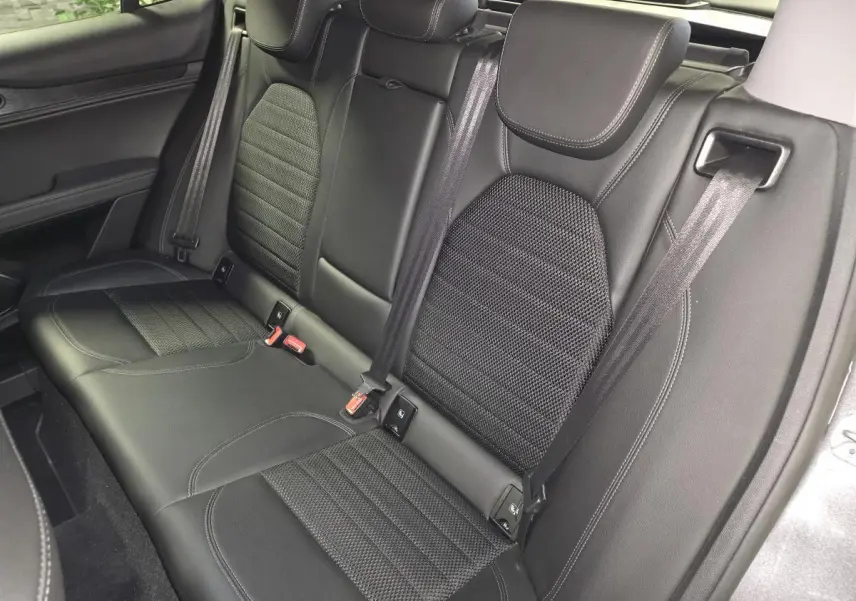 Vue rapprochée de la banquette arrière noire en tissu et cuir de l'Alfa Romeo Stelvio 2022, avec ceintures de sécurité visibles.