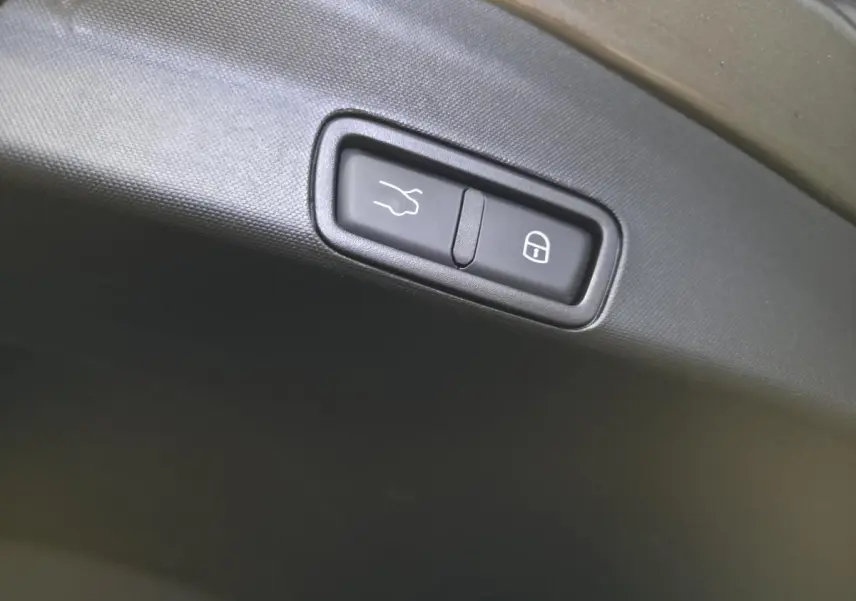 Boutons d'ouverture et de verrouillage du hayon électrique sur le coffre d'un Alfa Romeo Stelvio gris.