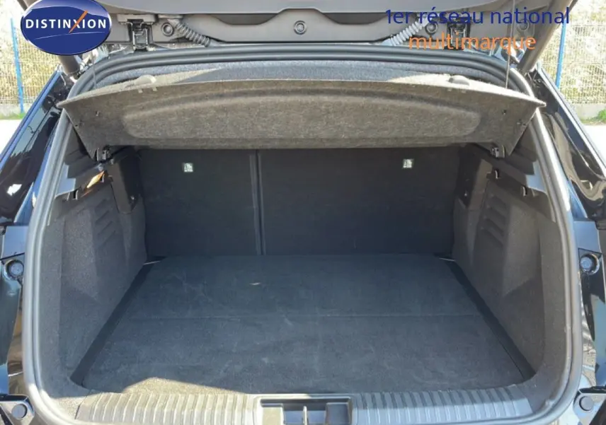 Coffre ouvert vu de l'arrière d'une Renault Symbioz noire étoile métal, montrant un espace de chargement vide et spacieux.