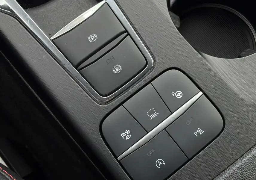 Gros plan sur la console centrale noire du Ford Kuga 2023 avec boutons de contrôle électronique et finition ST-Line.