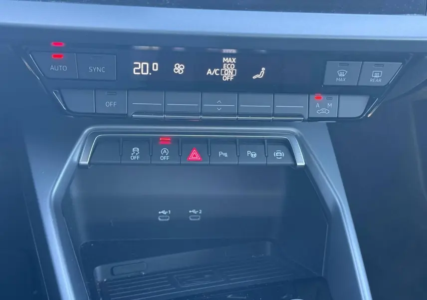Vue rapprochée de la console centrale de l'Audi A3 Sportback 2024, avec commandes clim et ports USB visibles.
