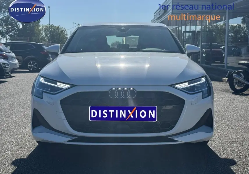Vue avant d'une Audi A3 Sportback 30 TFSI blanche Arkona avec calandre noire et phares LED distinctifs.