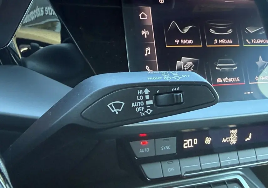 Gros plan sur la commande d’essuie-glace et l’écran tactile du tableau de bord de l’Audi A3 Sportback 2024.