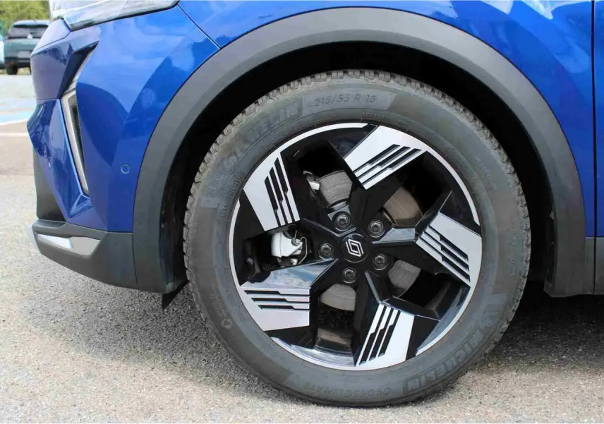 Gros plan sur la roue avant droite du Renault Symbioz bleu, avec jante alliage 19 pouces au design noir et argent.