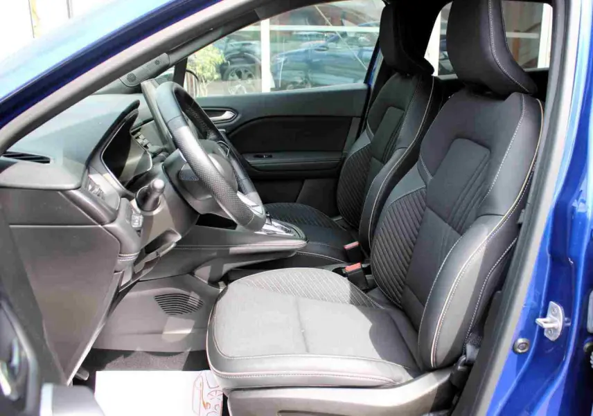 Vue intérieure côté gauche de la Renault Symbioz 2025 bleu, montrant les sièges avant et le volant textile refined.