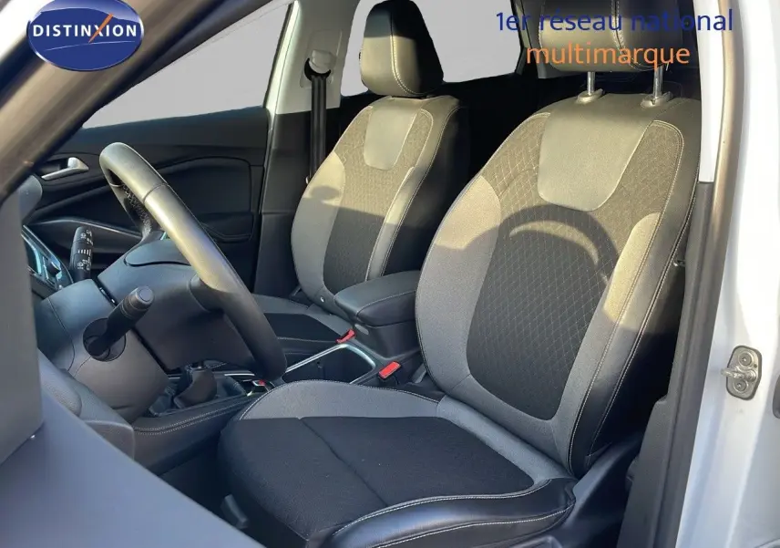 Intérieur avant droit de l'Opel Grandland X 2020 avec sièges tissu et cuir noir et gris, volant et levier de vitesses visibles.