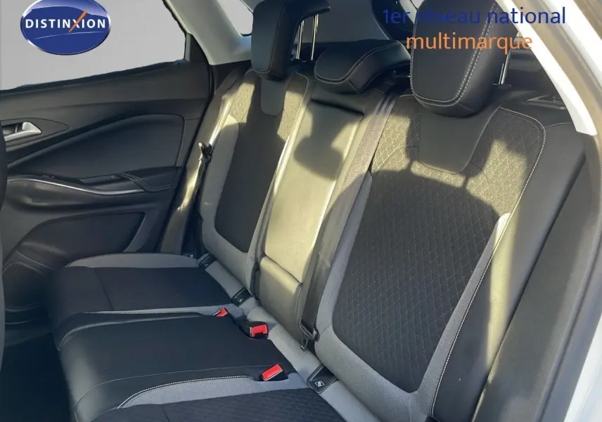 Vue latérale des sièges arrière en cuir noir et tissu gris d'un Opel Grandland X blanc toit noir de 2020.