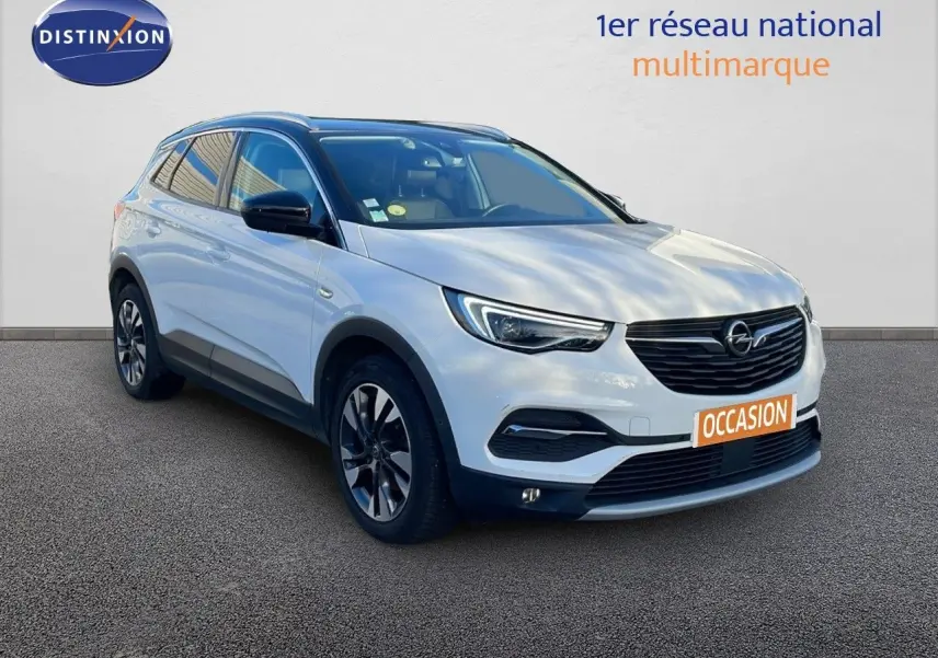 Opel Grandland X blanc toit noir en 3/4 avant droit avec jantes alliage et calandre noire distinctive.