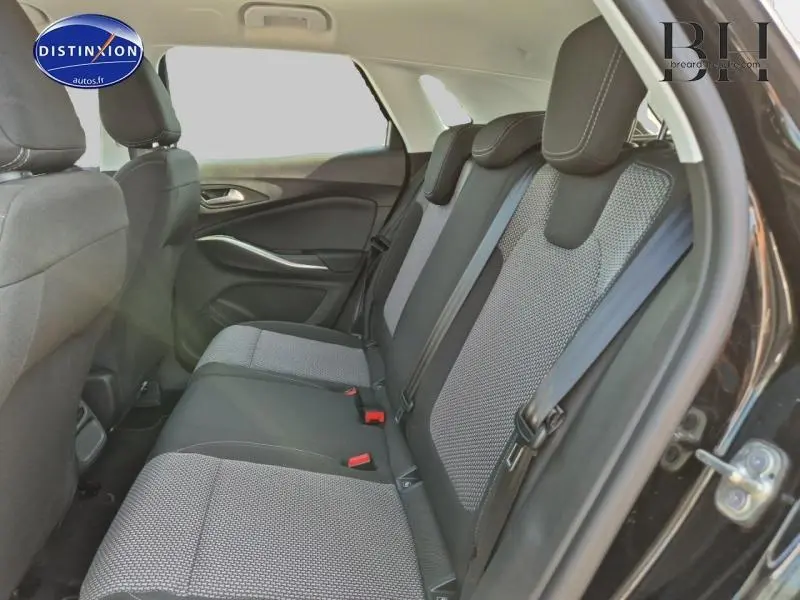 Vue latérale droite de l'intérieur arrière de l'Opel Grandland 2023 avec sièges tissu Berson noir et gris.