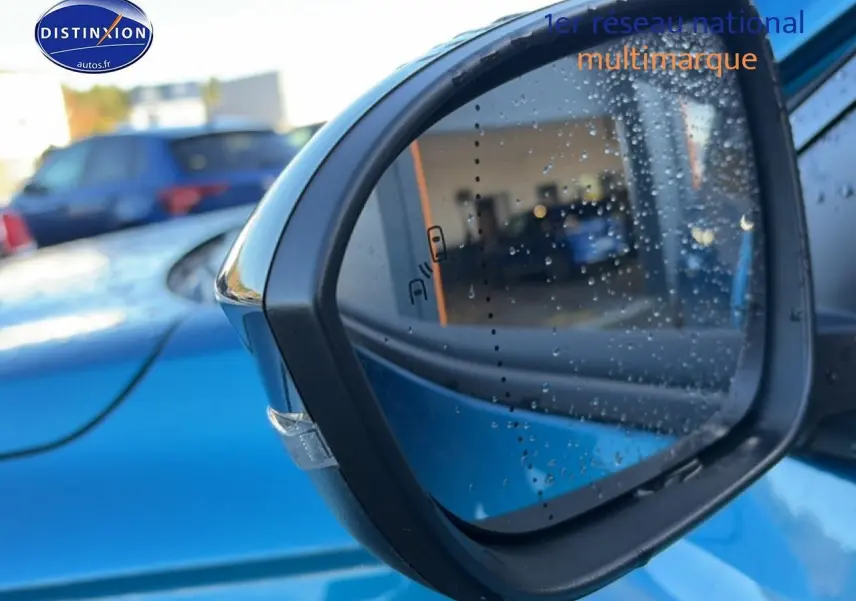 Rétroviseur extérieur droit bleu outremer de Renault Austral 2025 avec gouttes d'eau et capteur d'angle mort visible.