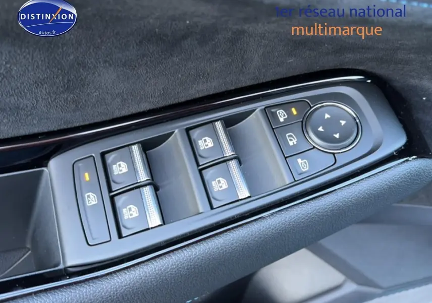 Gros plan sur les commandes des vitres électriques et rétroviseurs côté conducteur d’un Renault Austral bleu outremer.