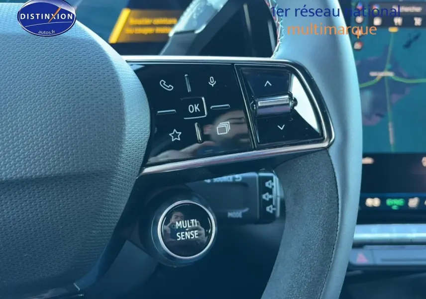 Gros plan sur le volant noir avec commandes multifonctions et bouton Multi-Sense du Renault Austral bleu outremer 2025.