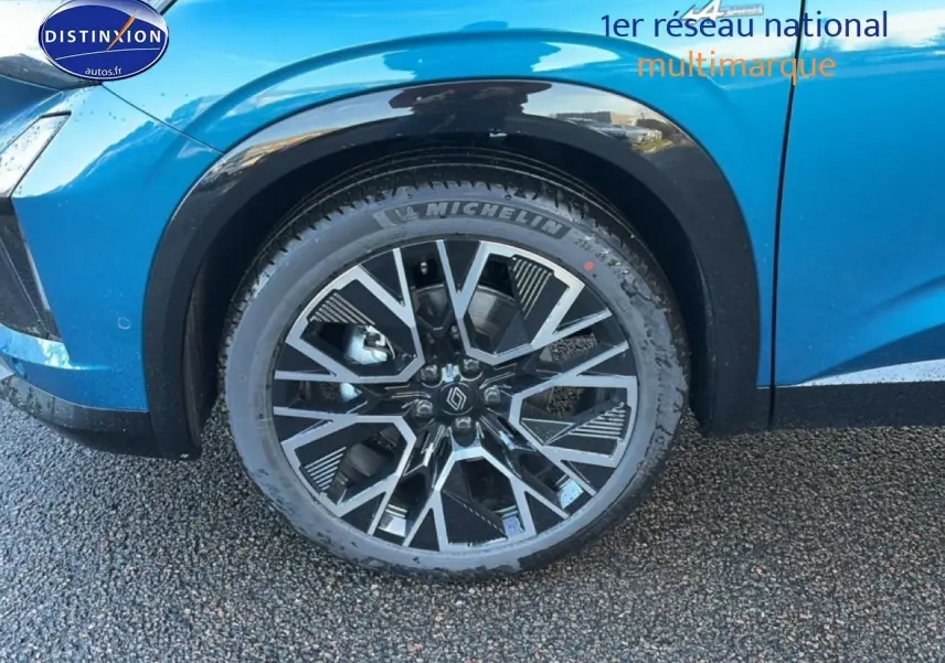 Gros plan sur la roue avant droite du Renault Austral bleu outremer avec jante alu au design géométrique.
