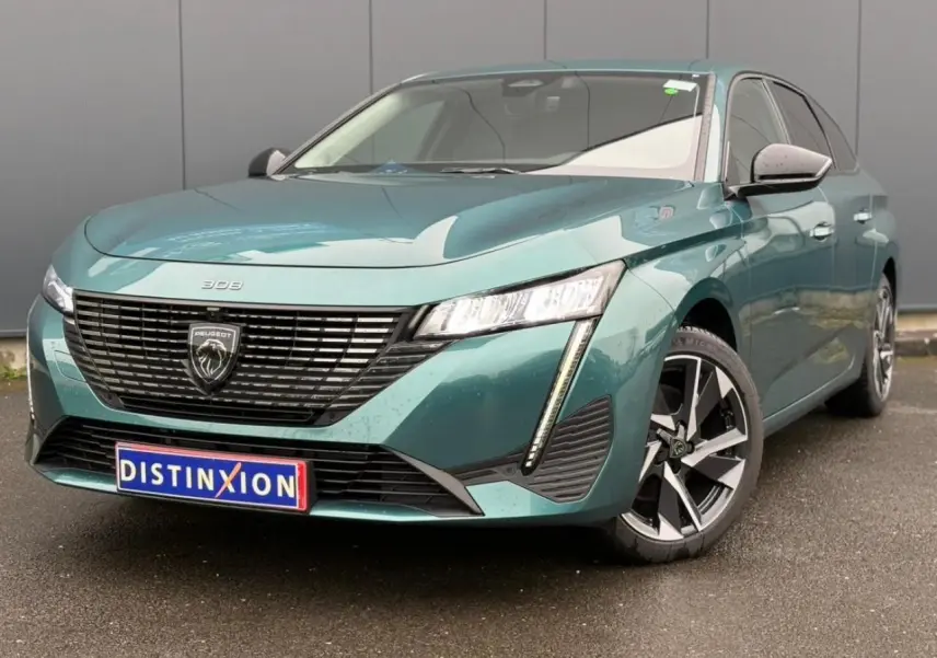 Peugeot 308 SW Hybrid bleu cuivre vue 3/4 avant droit avec calandre noire et jantes alliage 17 pouces.