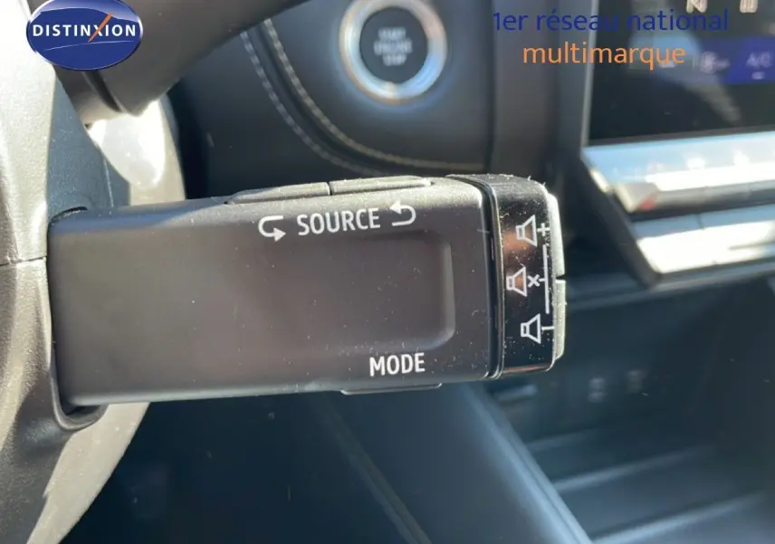 Gros plan sur la commande au volant gauche de la Renault Symbioz noire, avec bouton source et mode visible.