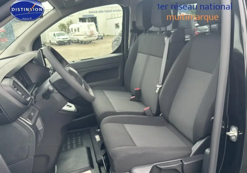 Vue intérieure côté conducteur du Fiat Scudo Combi noir 2026, montrant les sièges avant et le volant.